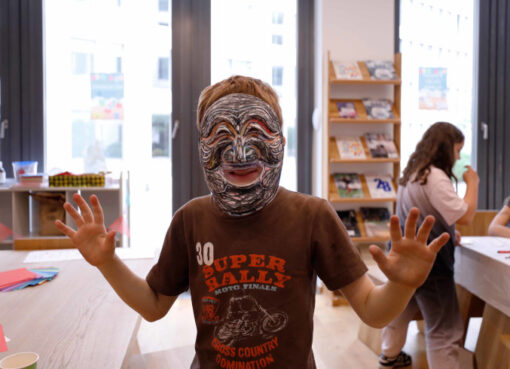 Schüler mit selbstbemalter traditioneller Maske