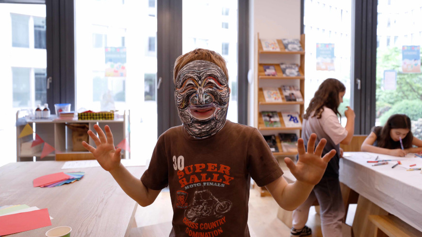 Schüler mit selbstbemalter traditioneller Maske