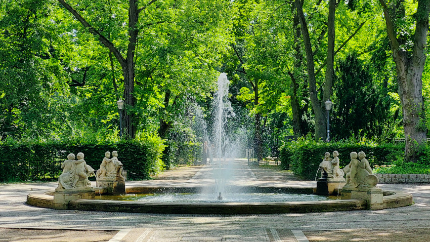 Der Delphinbrunnen lockt den Besucher in den Park hinein.